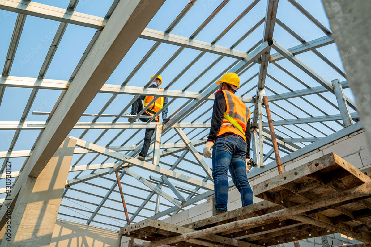 Construction workers building roof structure