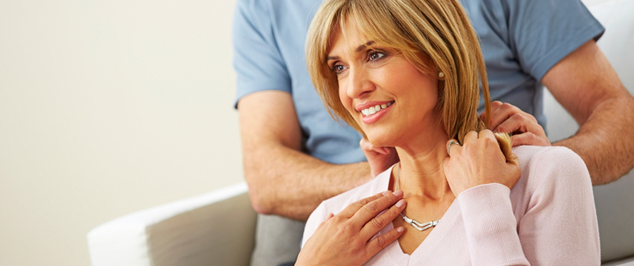 Man putting a necklace on a female