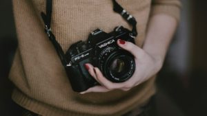 Female photographer cupping the lens of her camera