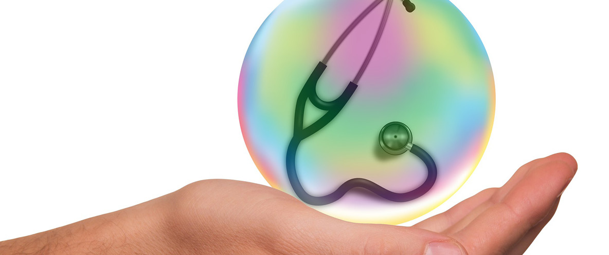 Cupped palm with a stethoscope in an orb hovering above it.