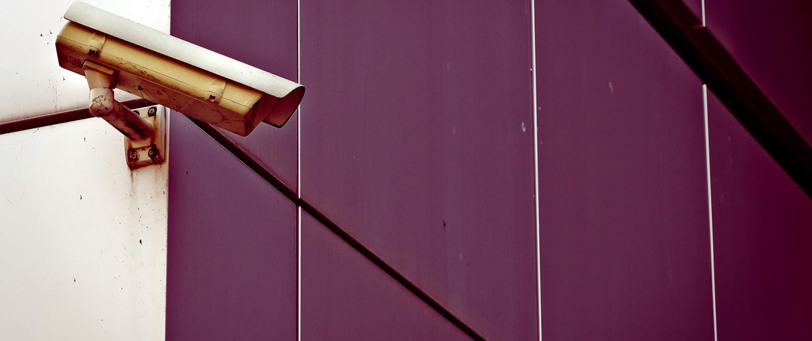 Video surveillance camera mounted on the edge of a building.