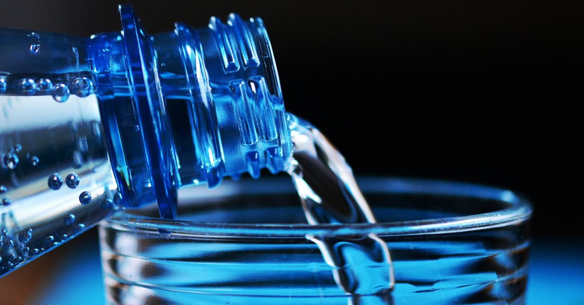 Water pouring into a glass from a water bottle