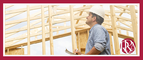 Construction working with hardhat looking up at building rafters