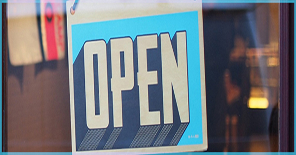 An open sign on an entry door to a store