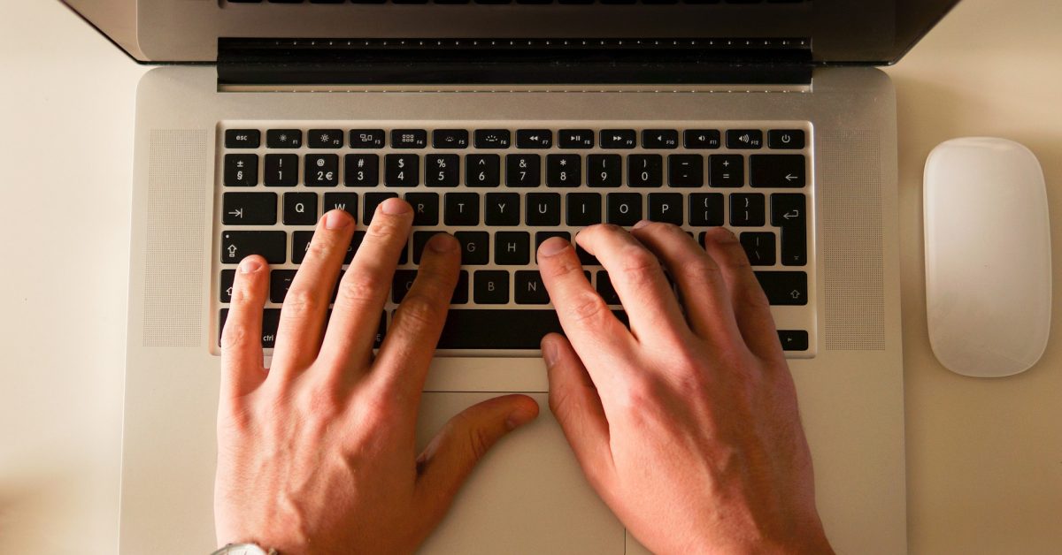 hands typing on laptop keyboard