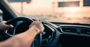 Car interior, driving with hands on the wheel