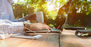 Holistic Well-being, male at a computer outside on a table