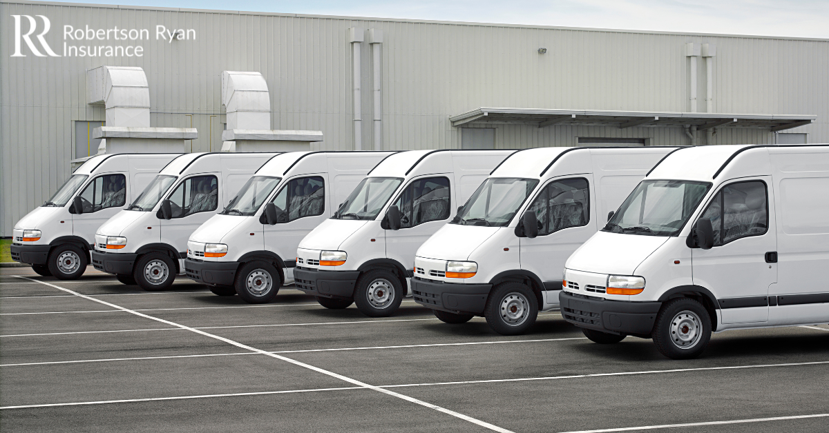 White fleet of vans in front of business